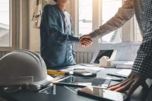 People shaking hands with clients to achieve agreement to work together at the office.